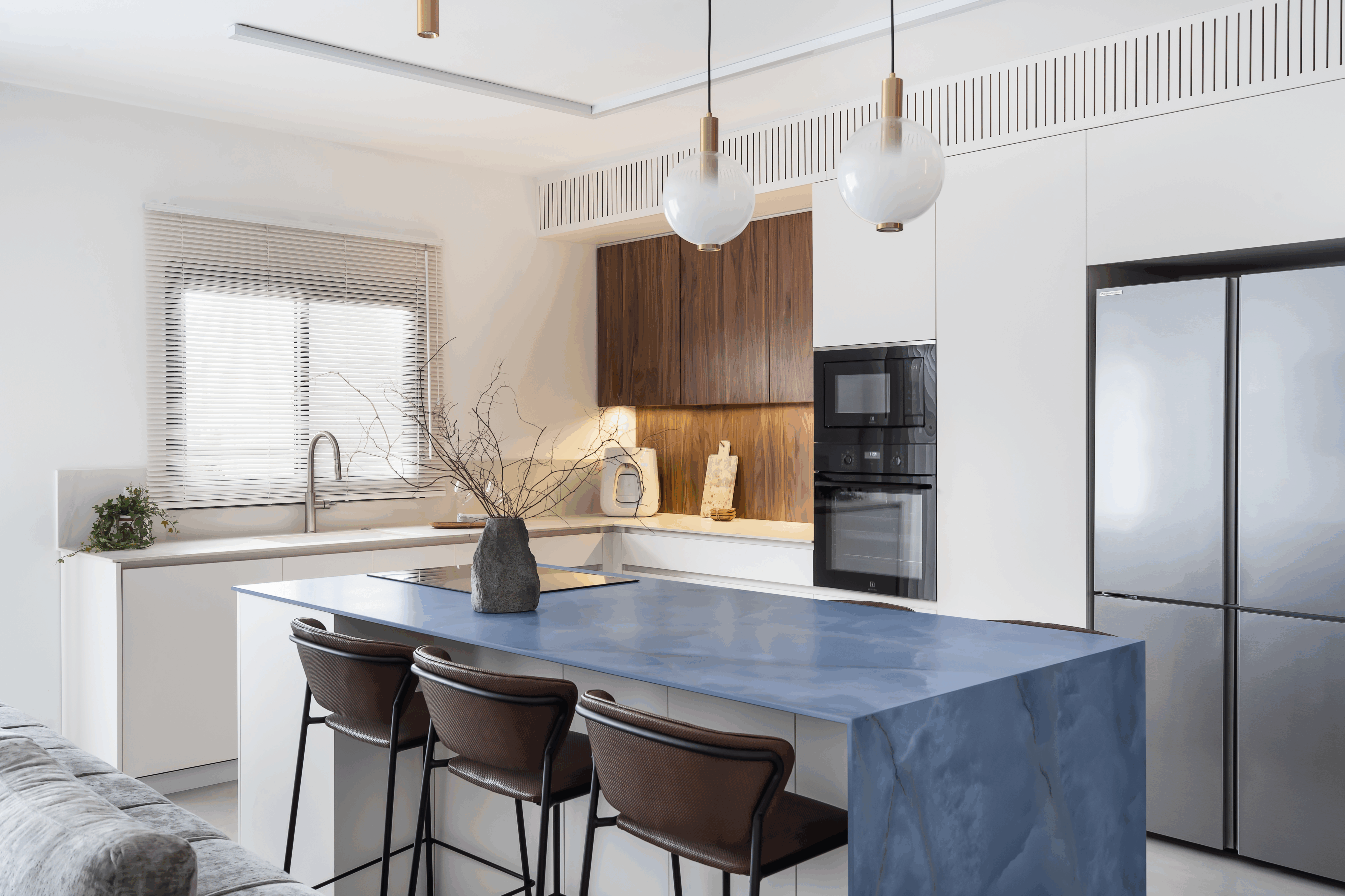 Cocina-comedor con el epicentro en la isla onice blue de ascale