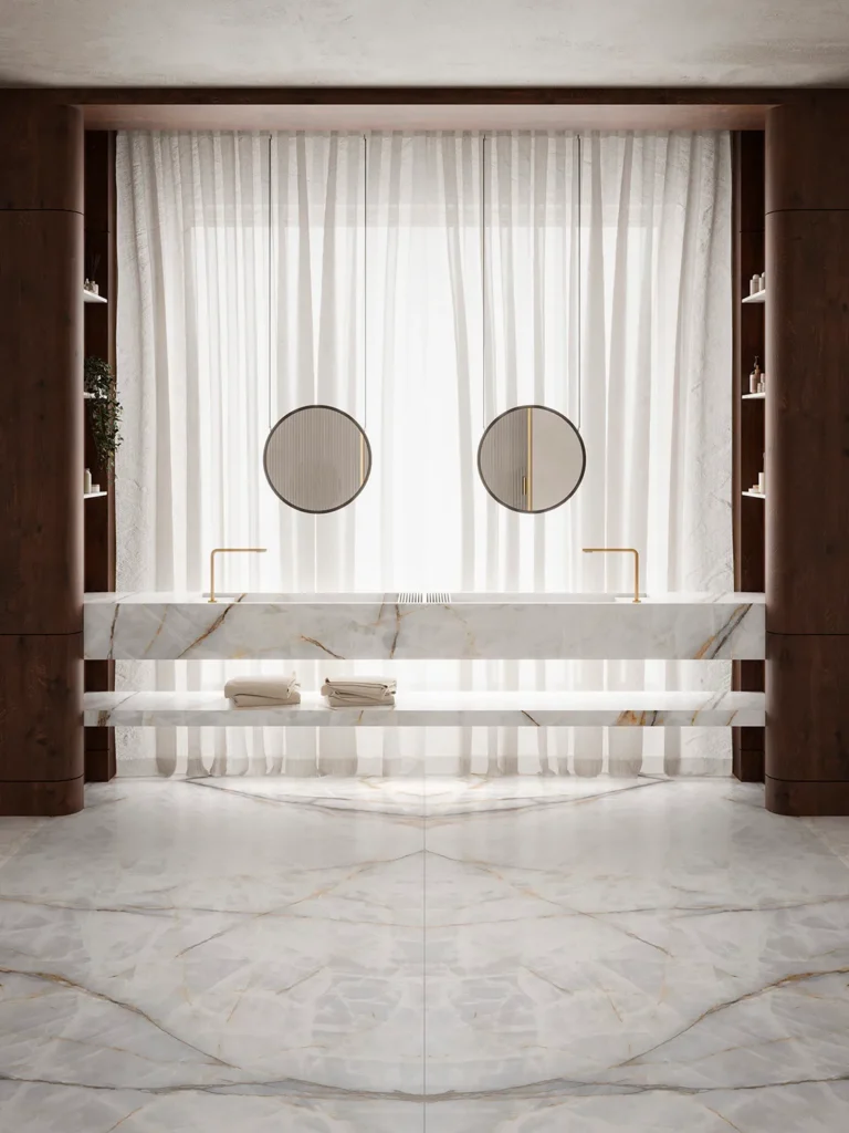 Baño contemporáneo con lavabos dobles revestidos en Aura Lux White, piedra sinterizada de Ascale. Las vetas doradas y grises se entrelazan sobre la superficie blanca, creando una textura visual dinámica que aporta profundidad y lujo al ambiente minimalista.