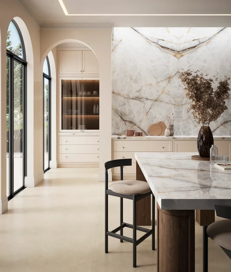 Cocina elegante con encimeras y revestimientos en Aura Lux White, piedra sinterizada de Ascale, donde las vetas ocres y grises recorren el fondo blanco luminoso, aportando sofisticación y carácter. La luz natural resalta la riqueza de sus detalles, transformando el espacio en un entorno cálido y distinguido.
